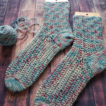 Multicolor crochet socks on wood panneling