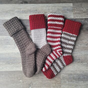 4 gnome-themed crochet stockings laying on a floor