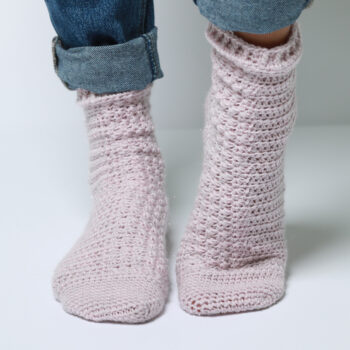 Pink crochet socks worn with folded blue jeans