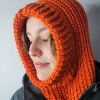 Orange Campfire winter hood under a black winter coat by smiling young woman