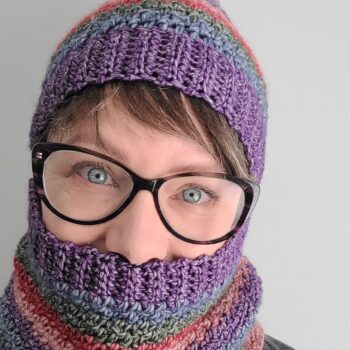 DaBoss striped crochet hat and cowl worn by woman wearing glasses.